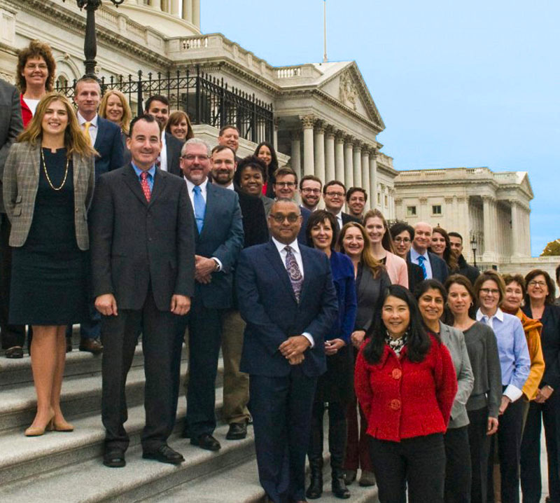 Cover of people standing on stairs on government building